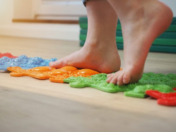 Kind läuft über Wackelmatten - Physiotherapie